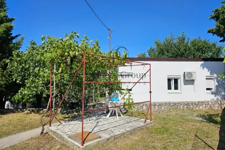 Kompaktna kuća sa ravnim placem na prodaju, idealna za privatan i miran život u predgrađu.